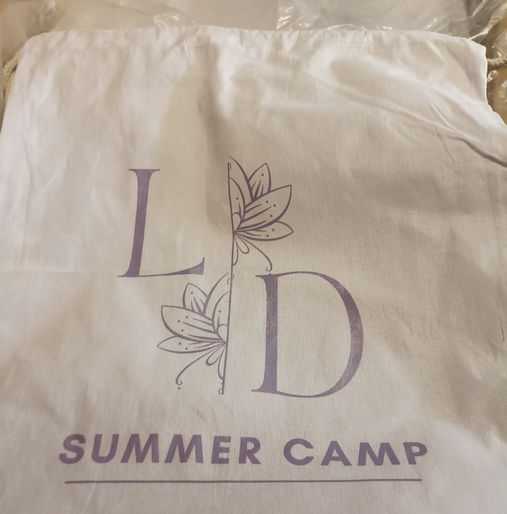 Biały workopecak na obóz letni - lawendowe logo summer campu.
